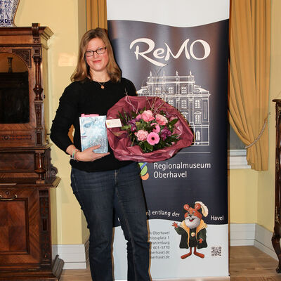 Anna Fleck mit ihrem Buch und einem Strauß Blumen in der Hand